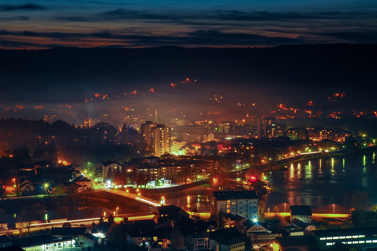 Noćni pogled na Novi Grad uz rijeku Unu osvijetljenu gradskim svjetlima.