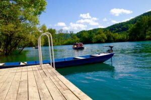 Drveni mol na rijeci Uni sa čamcem i rafting ekipom u daljini
