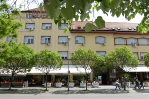 Ulaz u Hotel Zepter Palace u Banjoj Luci, okružen zelenilom i kafićima na glavnom trgu.