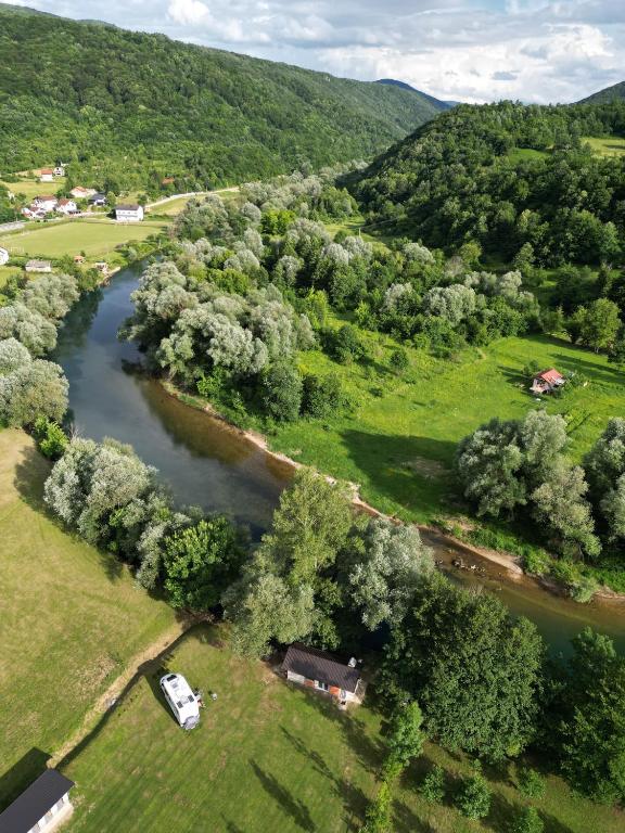 "Camping Status Quo Kulen Vakuf s terasom i pogledom na rijeku u prirodnom okruženju."