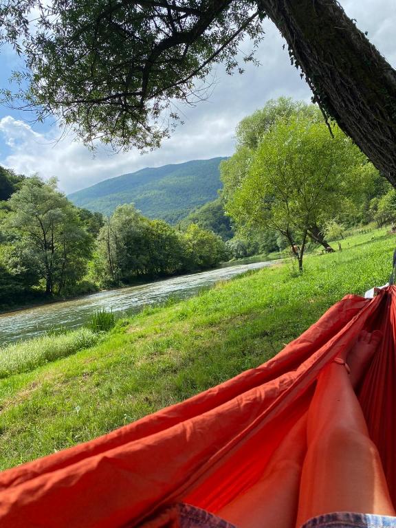 "Sana River Camp Ključ s vanjskom blagovaonicom i pogledom na rijeku u prirodnom okruženju."