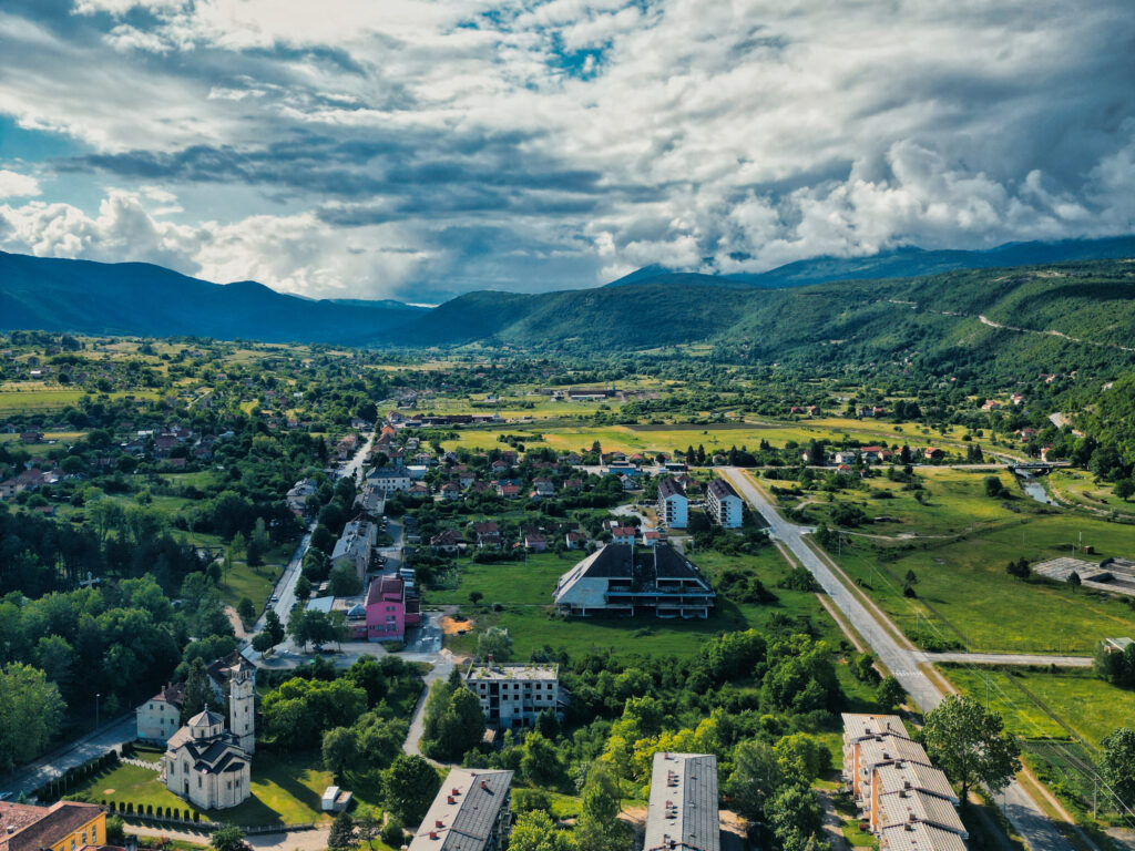 Panoramski pogled na Drvar i okolne planine pod vedrim nebom.